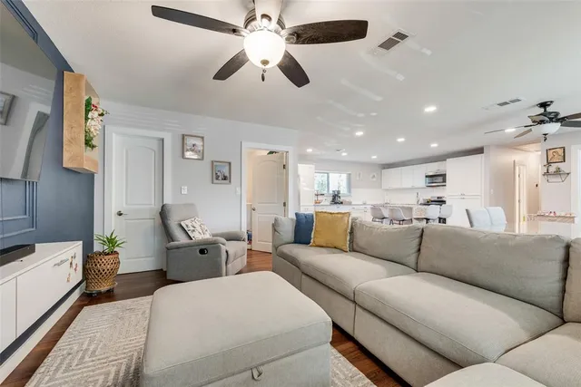 a living room with furniture kitchen view and a chandelier