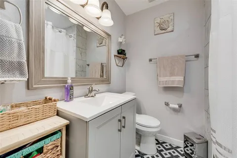 a bathroom with a sink toilet and a mirror