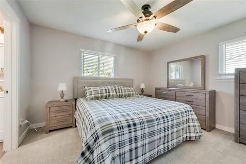 a bedroom with a bed a chandelier and a window