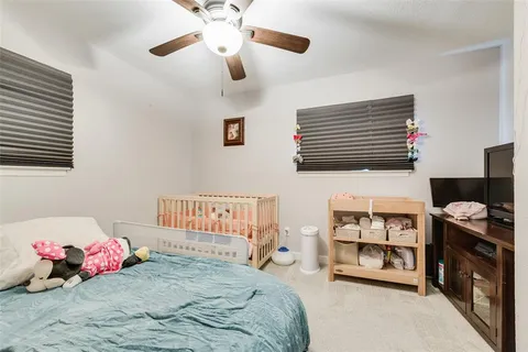 a bedroom with a bed dresser and a baby crib