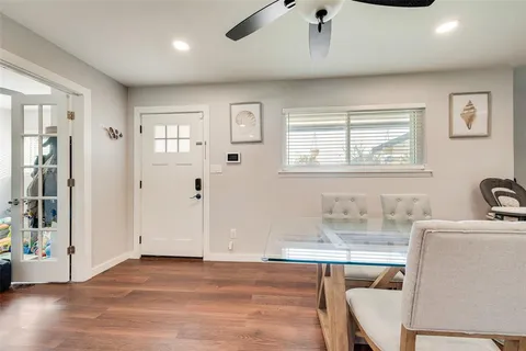 a view of a livingroom with furniture a ceiling fan and wooden floor