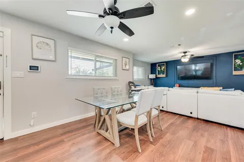 a view of a livingroom with furniture a flat screen tv a ceiling fan and wooden floor