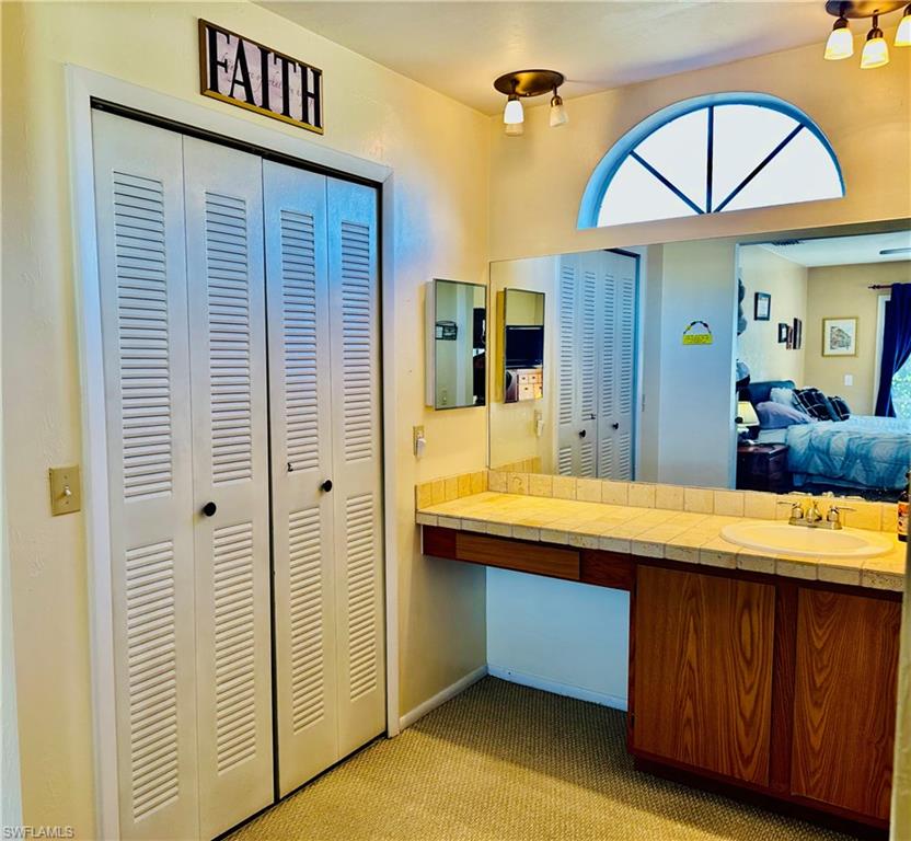 9108 Caloosa Road Fort Myers, FL 33967 - Photo 13 of 19 a bathroom with a sink a mirror and a shower
