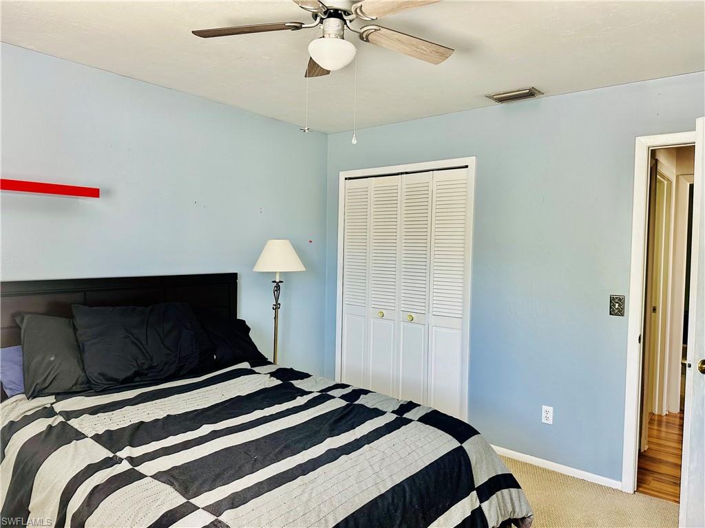 9108 Caloosa Road Fort Myers, FL 33967 - Photo 16 of 19 a bedroom with a bed and a chandelier