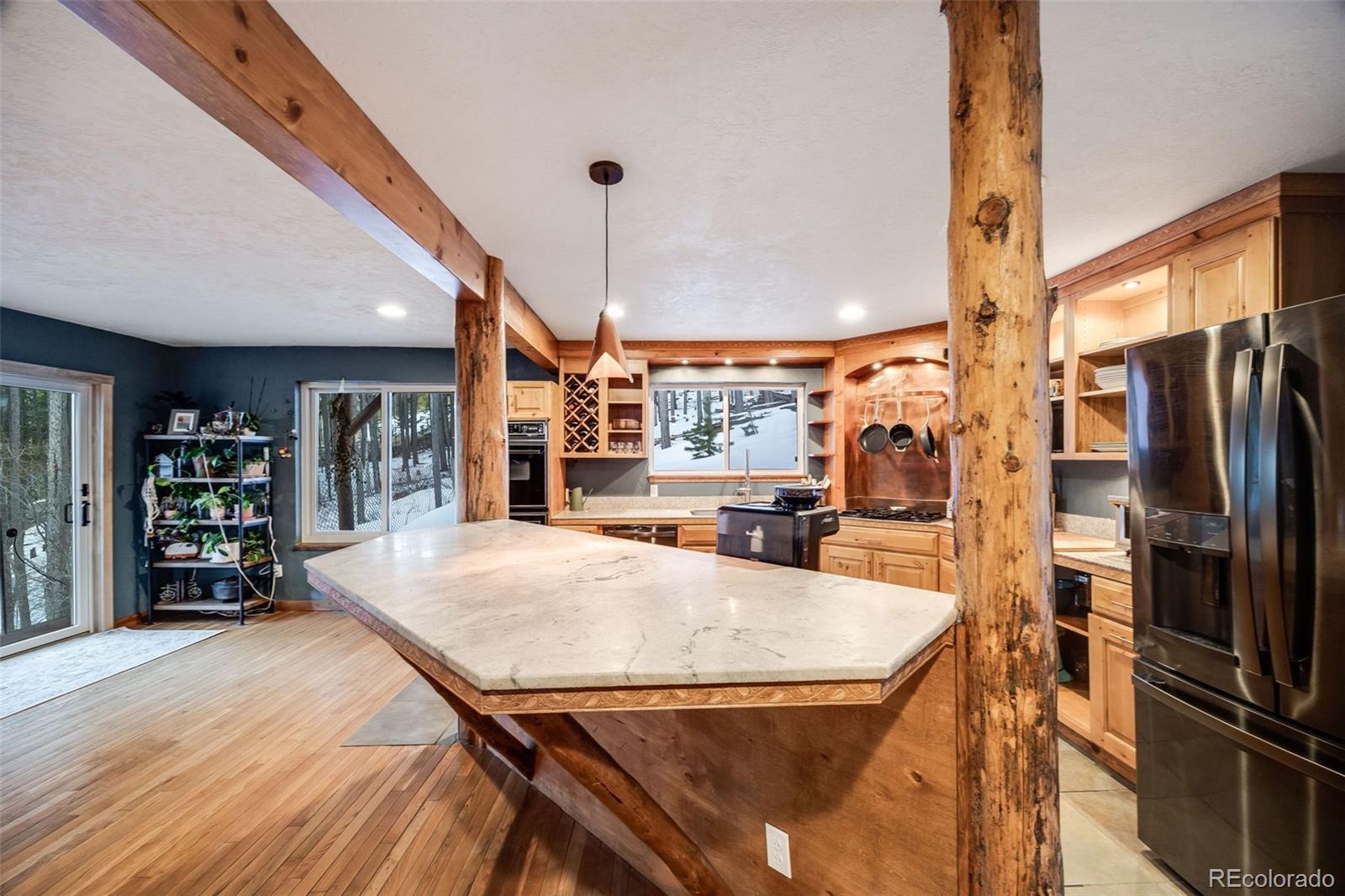 46 Apache Road Evergreen, CO 80439 - Photo 17 of 46 a open kitchen with stainless steel appliances granite countertop a refrigerator a oven a sink with island and chairs