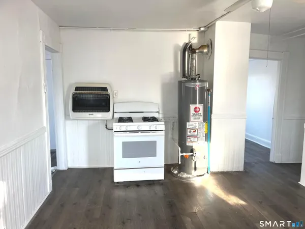 a kitchen with a refrigerator stove and wooden floor