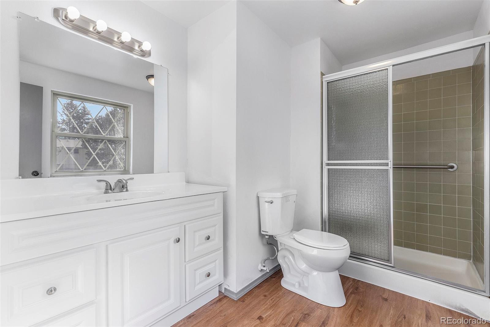 3792 South Fenton Way Denver, CO 80235 - Photo 12 of 19 a bathroom with a toilet sink and mirror