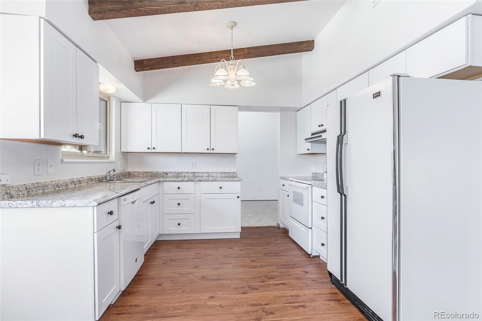 3792 South Fenton Way Denver, CO 80235 - Photo 4 of 19 a kitchen with white cabinets and white appliances