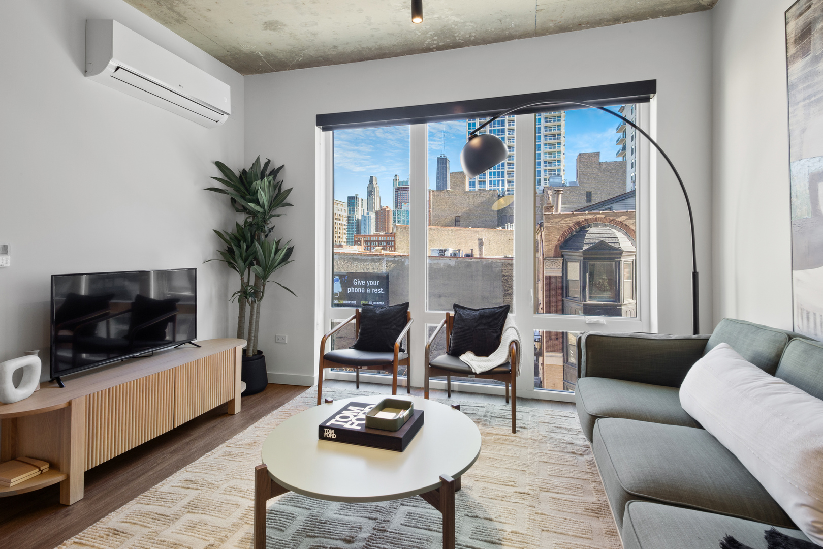 411 West Chicago Avenue, Unit C806 Chicago, IL 60654 - Photo 11 of 16 a living room with furniture a flat screen tv and a large window