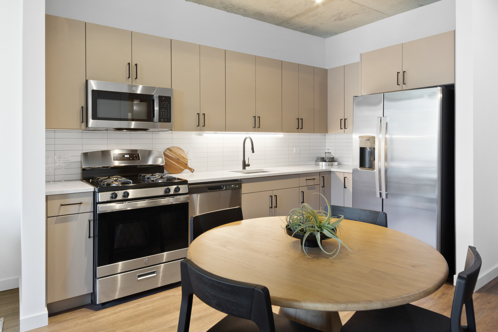 411 West Chicago Avenue, Unit C806 Chicago, IL 60654 - Photo 3 of 16 a kitchen with a sink a stove a refrigerator and chairs