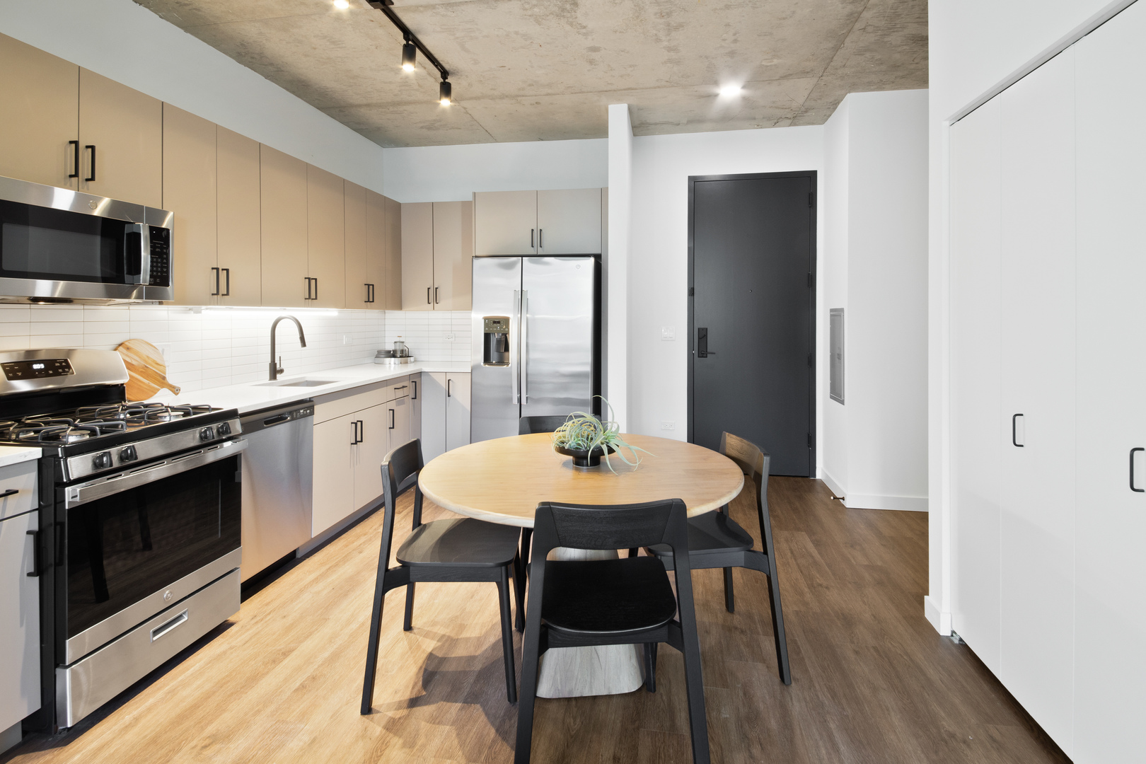 411 West Chicago Avenue, Unit C806 Chicago, IL 60654 - Photo 7 of 16 a kitchen with stainless steel appliances a dining table chairs stove microwave and cabinets