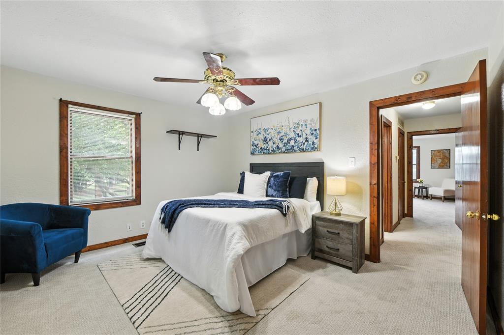 1323 Dublin Street Grapevine, TX 76051 - Photo 22 of 40 a bedroom with a bed a chandelier and a couch