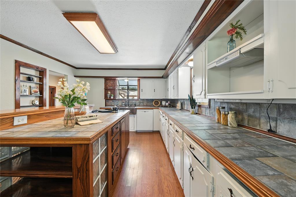 1323 Dublin Street Grapevine, TX 76051 - Photo 33 of 40 a kitchen with stainless steel appliances granite countertop sink stove and wooden floor