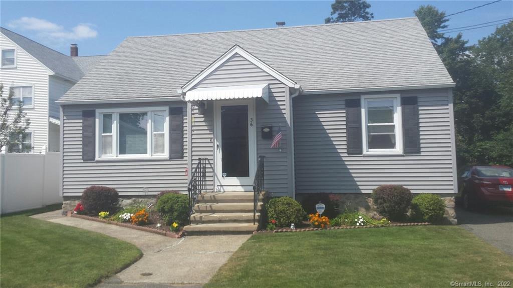 a front view of a house with a yard and outdoor seating