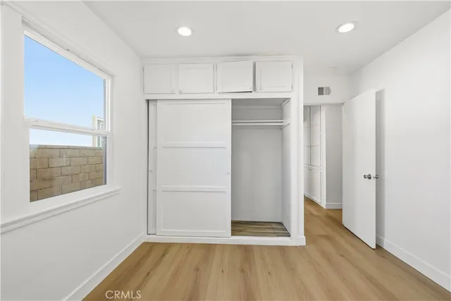 a view of empty room with wooden floor and cabinet