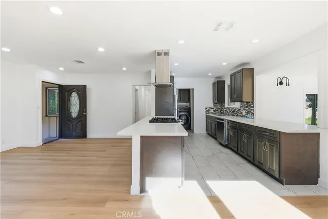 a large kitchen with stainless steel appliances kitchen island a large counter top and a view of living room