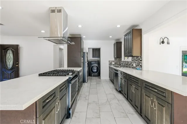 a large kitchen with stainless steel appliances granite countertop a sink stove and refrigerator