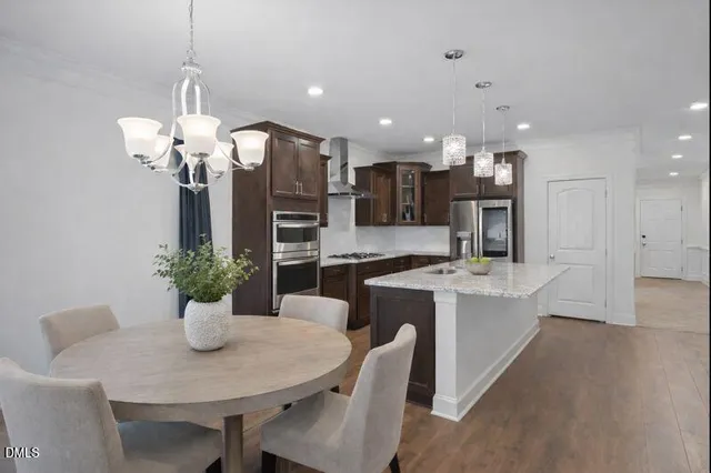 a living room with furniture a fireplace and a chandelier