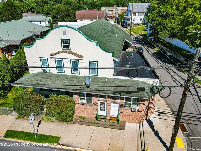an aerial view of a house with swimming pool and sitting space