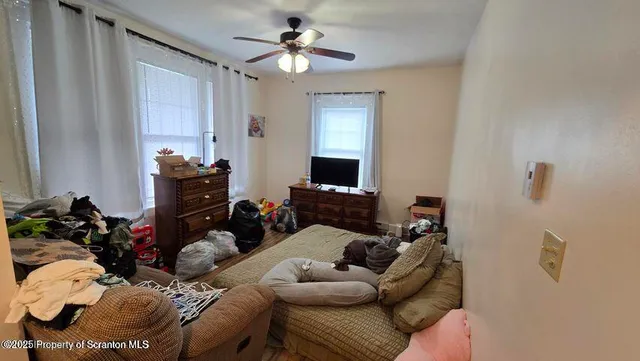 a bed sitting in a bedroom next to a window and a chandelier