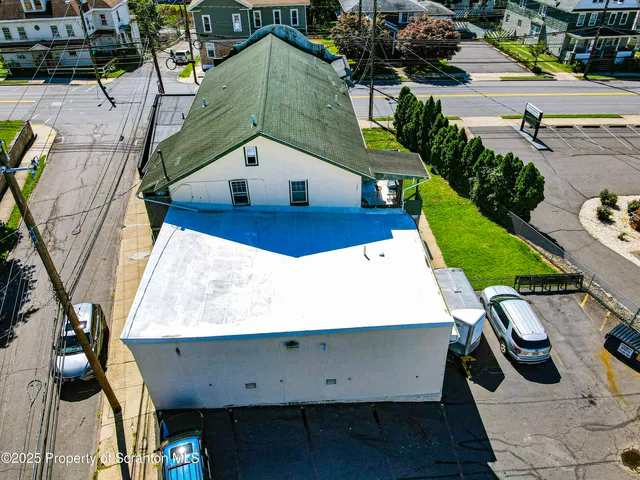 an aerial view of a house with swimming pool and large trees