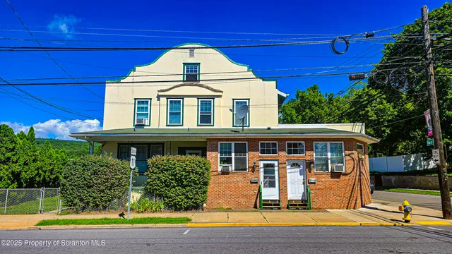a view of a white building with swimming pool in front of it