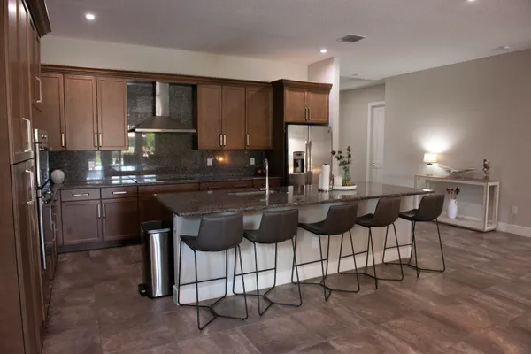 a kitchen with kitchen island granite countertop a sink and cabinets