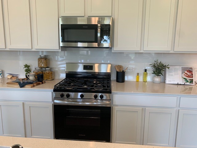 415 Robin Court Angleton, TX 77515 - Photo 8 of 9 a kitchen with stainless steel appliances granite countertop white cabinets a stove top oven