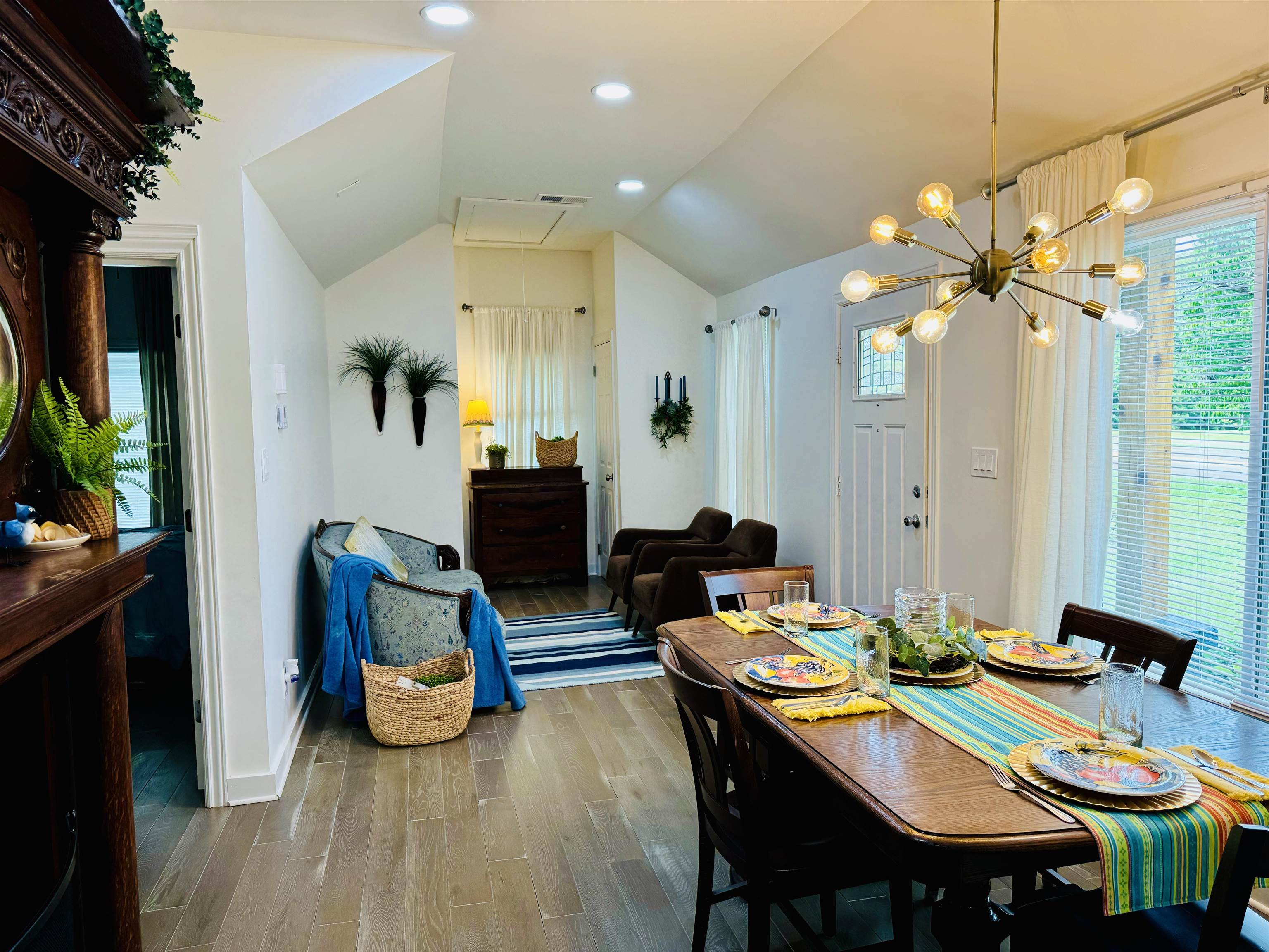 Dining space with hardwood / wood-style flooring, a chandelier, and vaulted ceiling