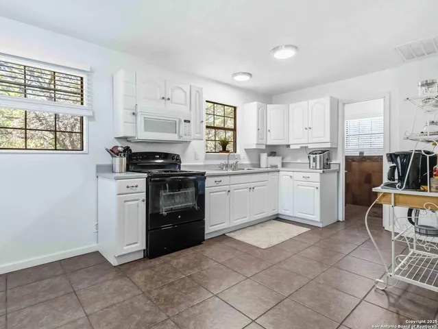a kitchen with a stove top oven sink and cabinets