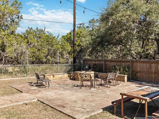 a view of backyard with a table and chairs with wooden fence
