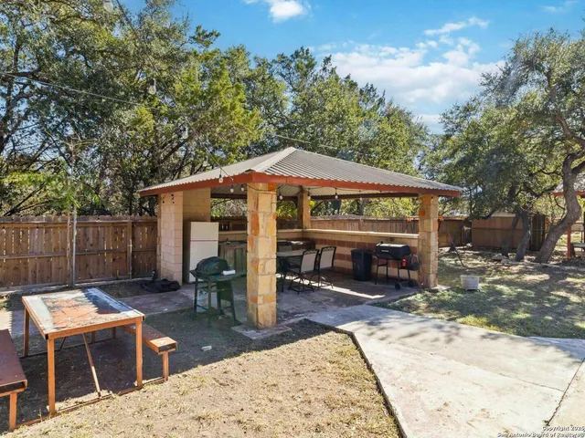 a view of a patio with a table and chairs under an umbrella