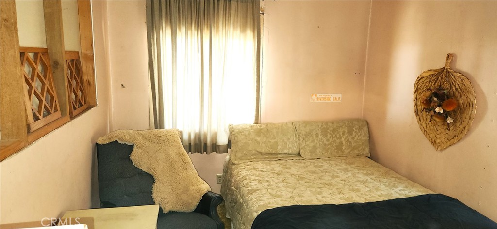 60812 Adele Road Landers, CA 92285 - Photo 12 of 19 a bedroom with a bed and a chair