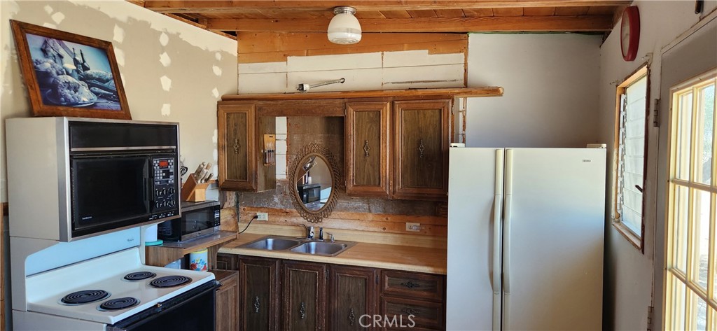 60812 Adele Road Landers, CA 92285 - Photo 6 of 19 a kitchen with a refrigerator and a sink