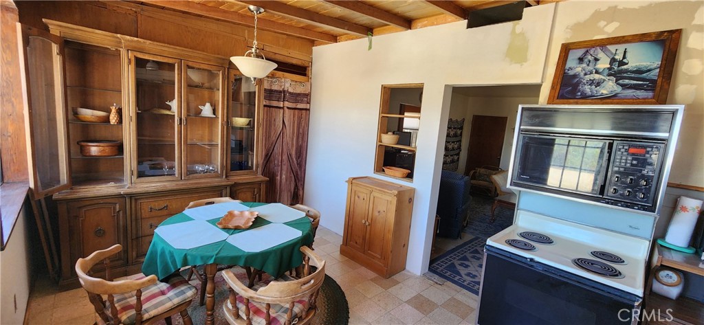 60812 Adele Road Landers, CA 92285 - Photo 7 of 19 a view of a dining room with furniture a rug and wooden floor
