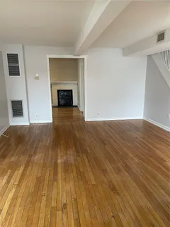a view of empty room with wooden floor and fireplace
