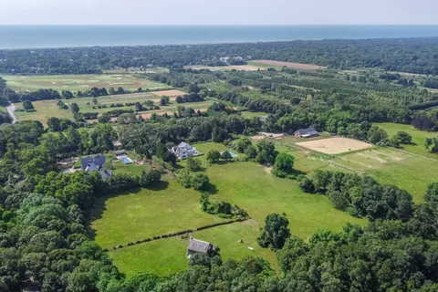 an aerial view of a house with a garden and lake view