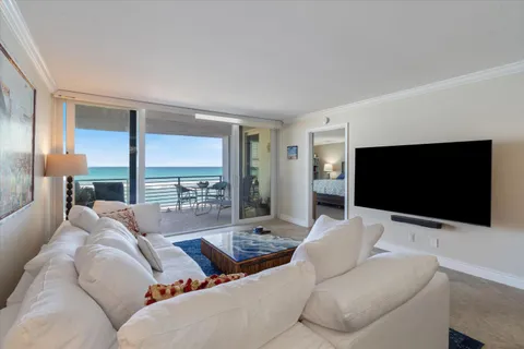 a living room with couches a flat screen tv and a large window