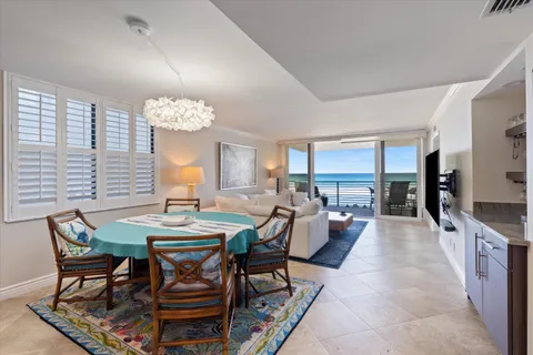 a view of a dining room and livingroom with furniture wooden floor a rug a chandelier