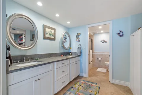 a bathroom with a granite countertop double vanity sink and a mirror