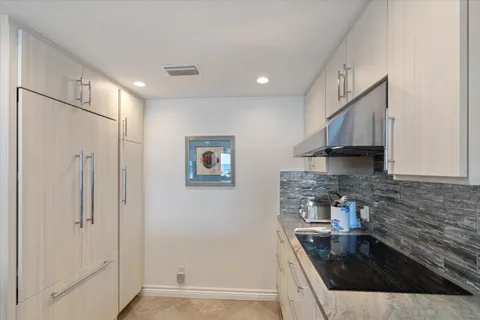 a kitchen with granite countertop a sink stove and refrigerator
