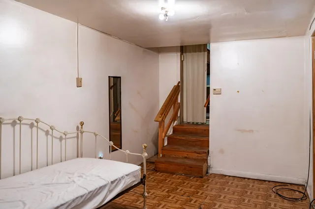 a bedroom with a bed and a view of entryway