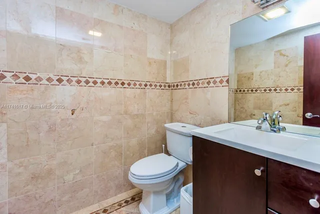 a bathroom with a granite countertop sink a toilet and shower