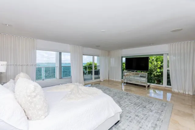 a bedroom with a bed lamp and a large window