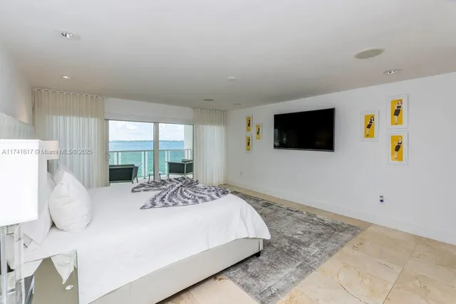 a bedroom with furniture and a large window