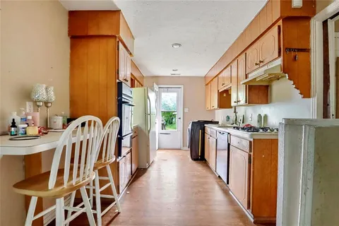 a kitchen with stainless steel appliances granite countertop a sink a stove and a refrigerator