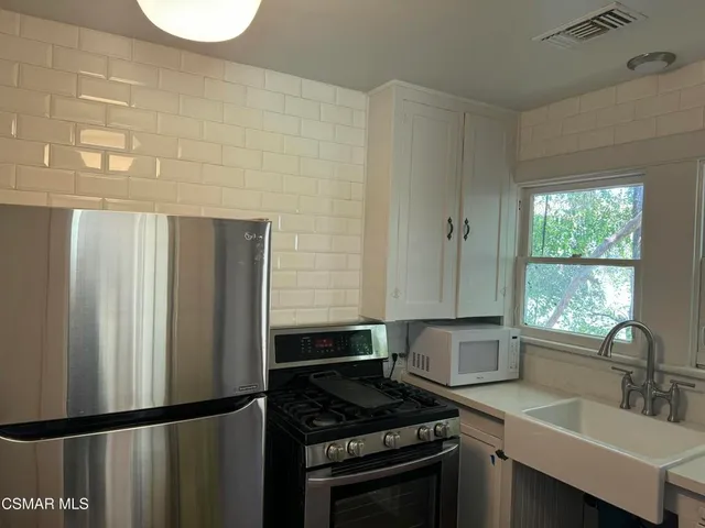 a kitchen with granite countertop a sink stove and refrigerator