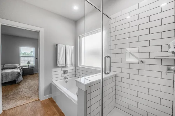 a bathroom with a tub sink and mirror