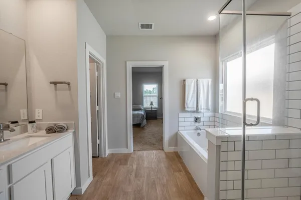 a bathroom with a double vanity sink a mirror and a bathtub