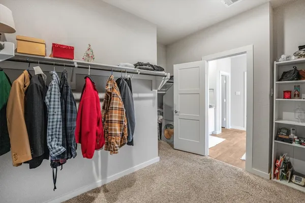 a view of walk in closet with clothes and shoes